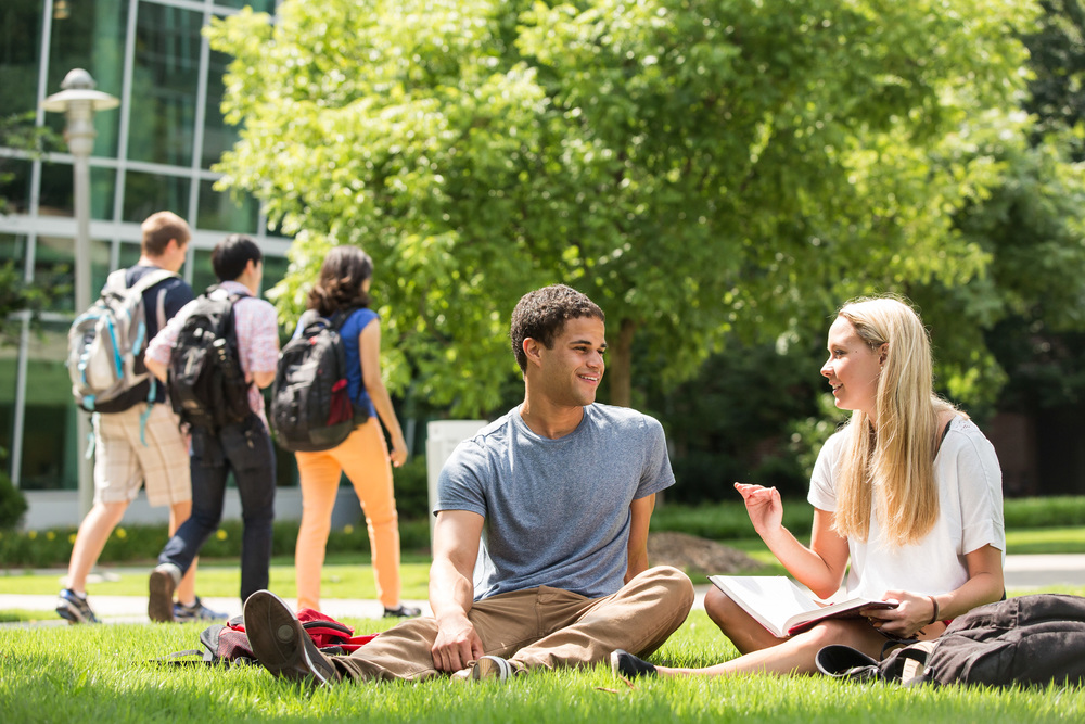 Two students studying outside in front of Ford Environmental Science & Technology Building